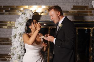 Two people share an intimate moment during a romantic wedding ceremony in a rustic brick room.
