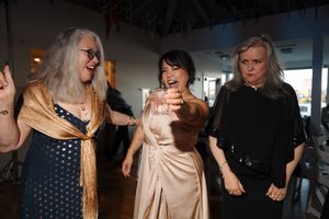 A group of people laughing and dancing together at a social gathering with festive atmosphere.
