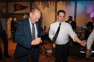 Guests dancing together at a lively wedding celebration in an elegant indoor venue.