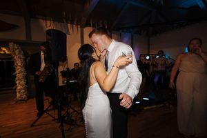 A couple shares a romantic dance together during what appears to be their wedding reception.