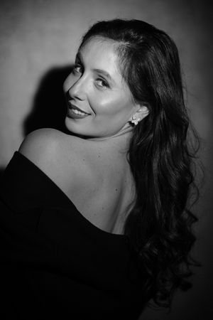 Black and white portrait with dramatic lighting and off-shoulder styling.