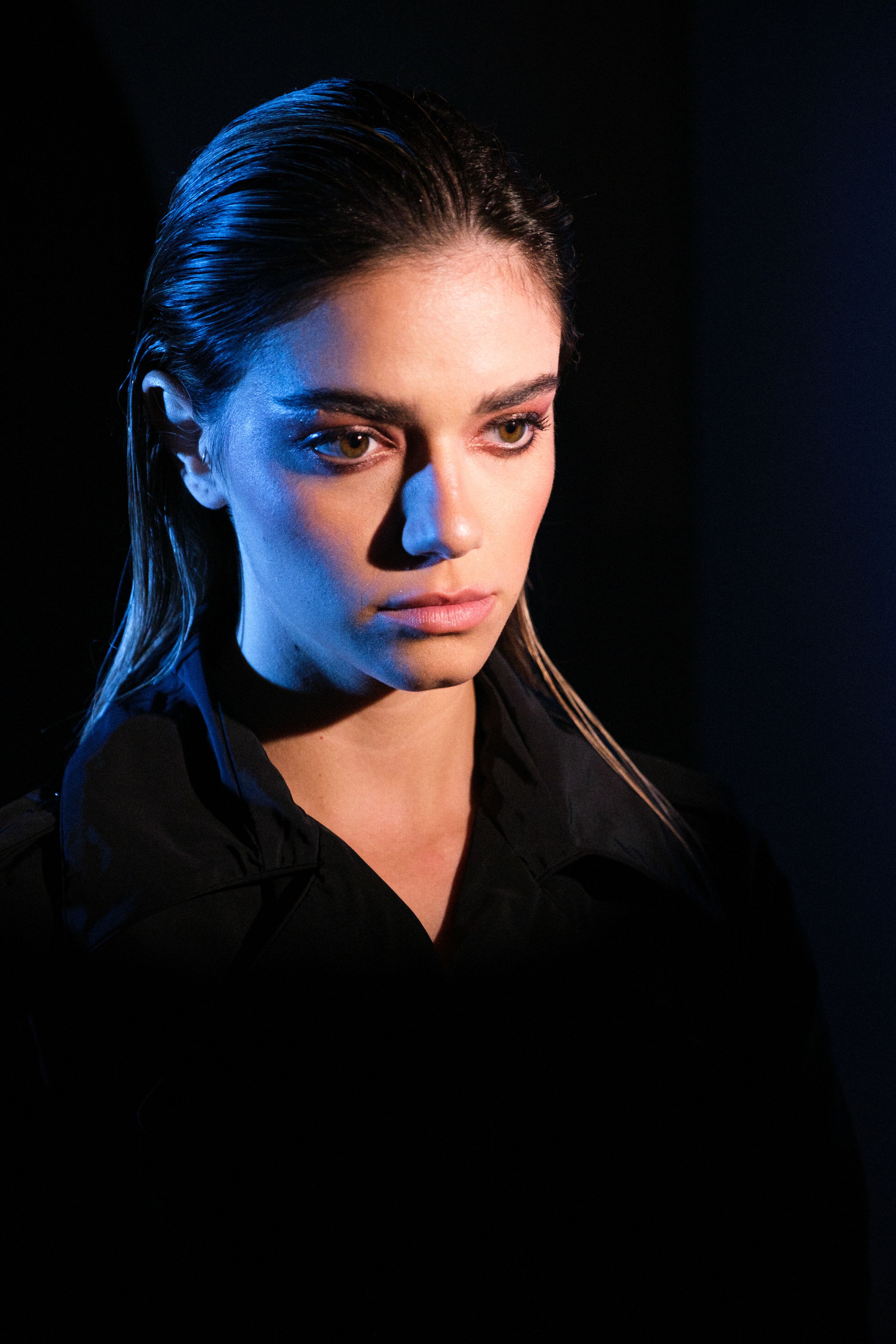 Dramatic portrait series with blue lighting creating mysterious shadows and highlights.