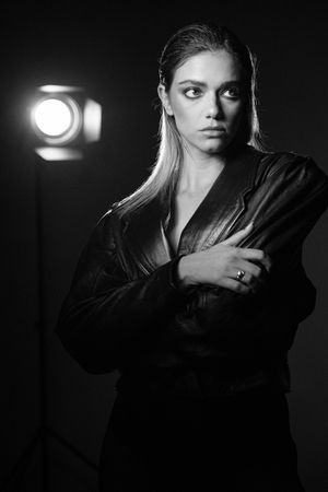 Dramatic black and white portrait with studio lighting and leather jacket.