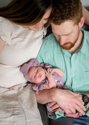 A sequence of photos shows a person in a mint green shirt holding and comforting a crying baby in purple clothing.
