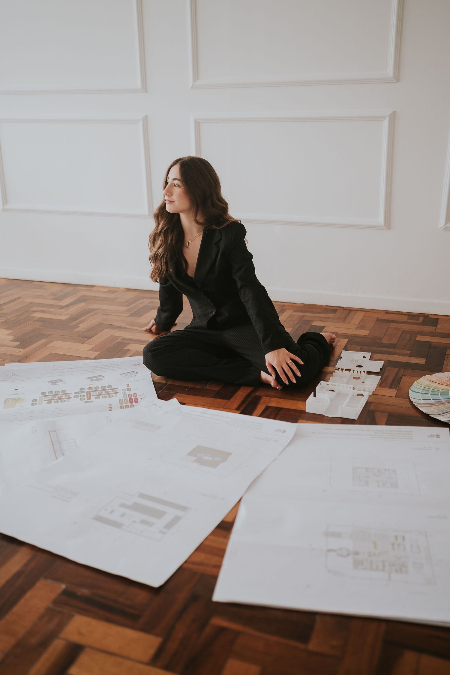 Creative flat lay view of someone reviewing documents on herringbone wooden floor.