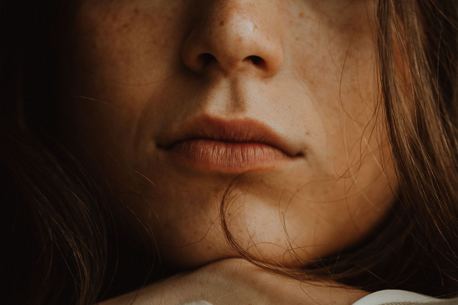 Close-up portrait series focusing on facial features in warm, moody lighting.