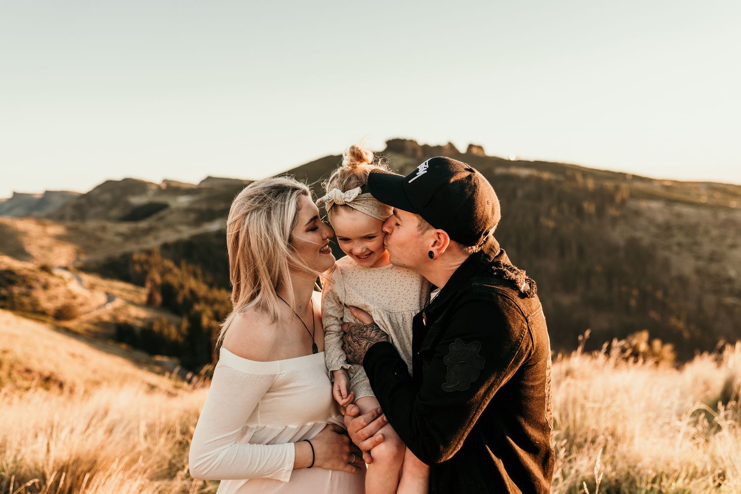 Intimate family embrace captured at sunset on a scenic mountain overlook.