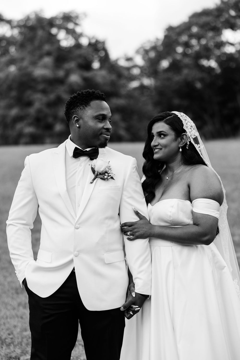 Black and white photo sequence shows wedding couple sharing intimate moments outdoors in white formal attire.