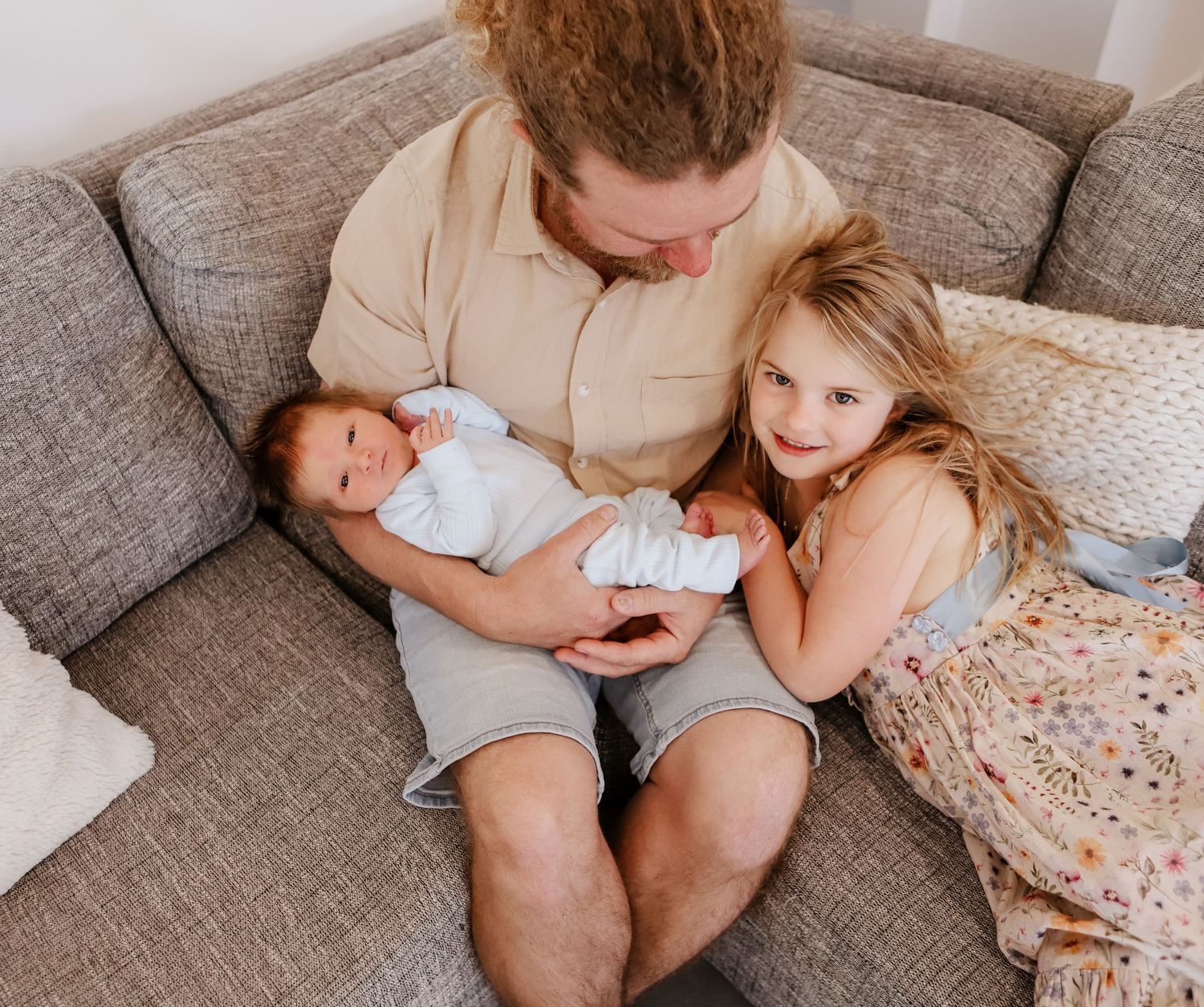 A cozy family moment captured in a sequence of candid shots showing parents and children relaxing together on a gray couch.