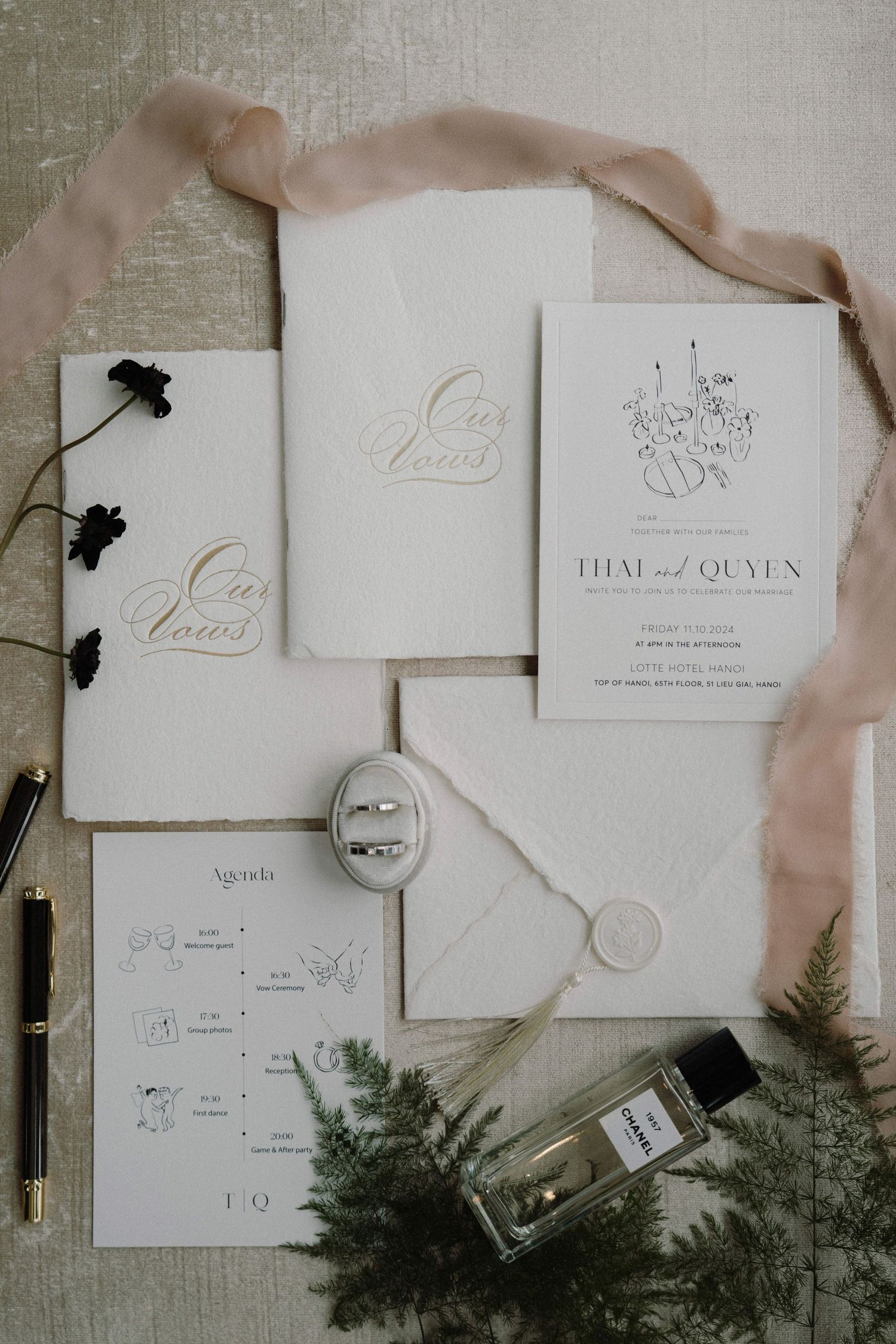 Elegant white wedding invitations with calligraphy and greenery accents.