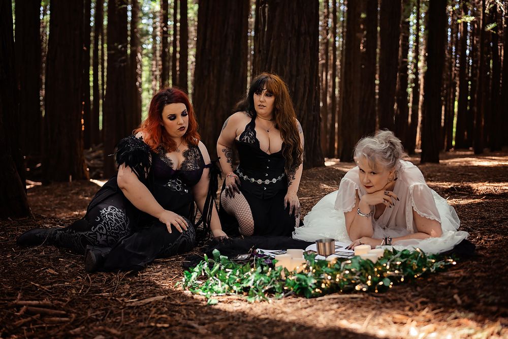People lay on a forest floor amid redwood trees in a dreamy outdoor photography session.