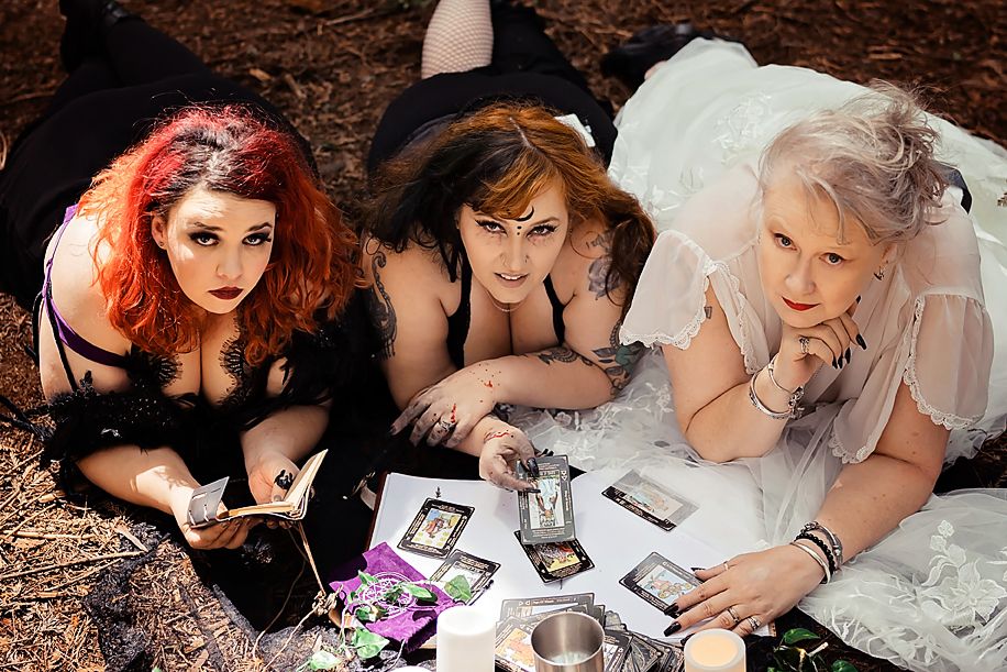 Friends lounging on forest ground in formal attire creating candid moments among the trees.