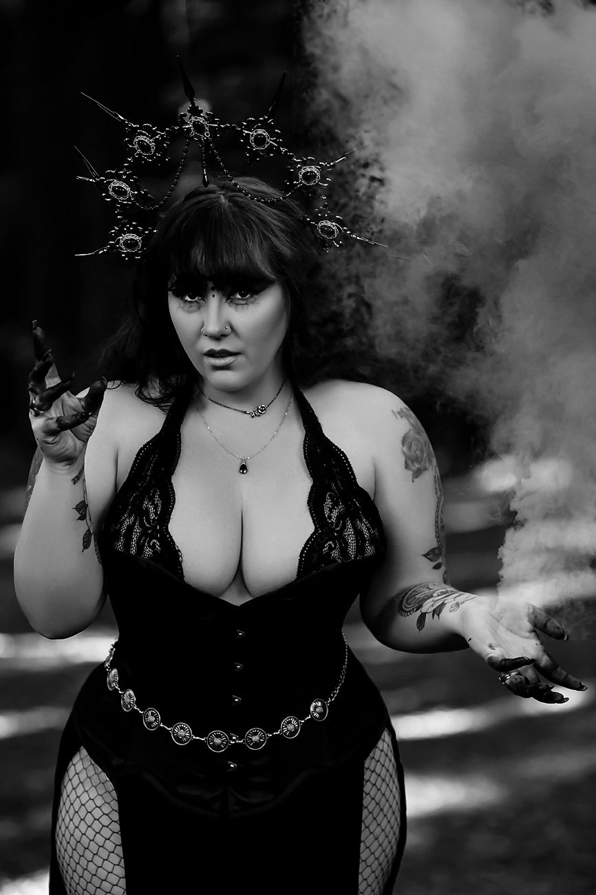 Atmospheric black and white portrait with dramatic smoke effects and gothic styling.