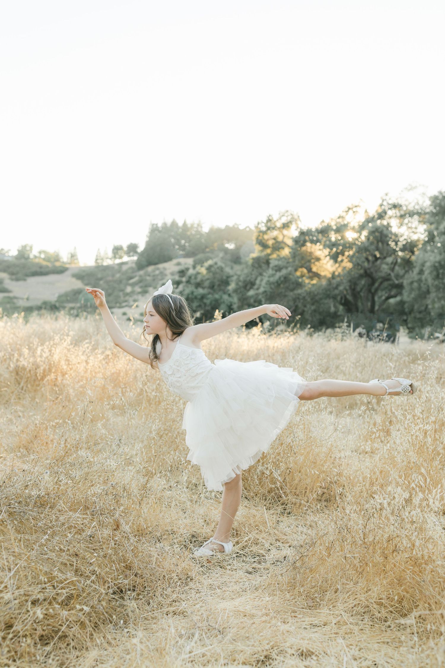 Elegant white lace T-strap bridal flats with pearl embellishments photographed on hay captured by Chelsee Rawe Photography.