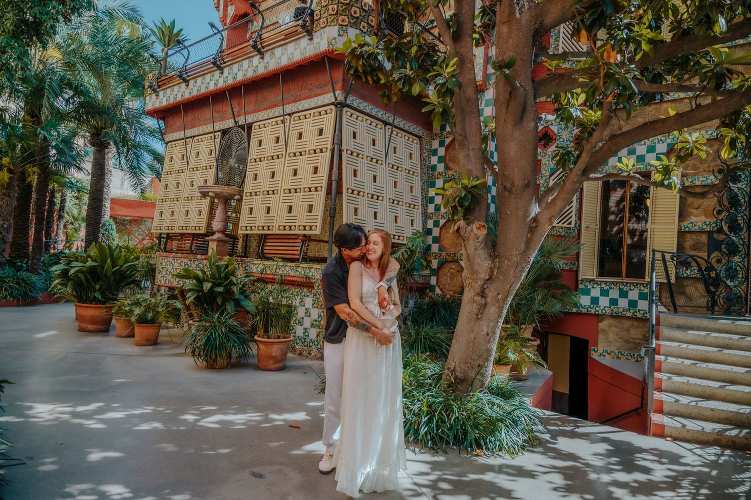 Expecting parents embracing tenderly in front of Casa Vicens’ vibrant tiles in Barcelona.