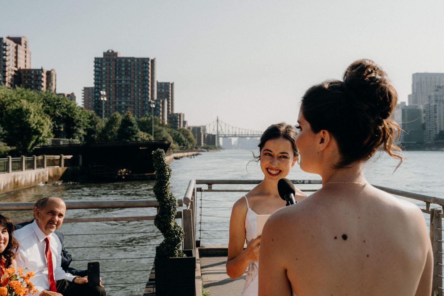 Couple sits at edge of East River for wedding at the Sanctuary Roosevelt Island NYC