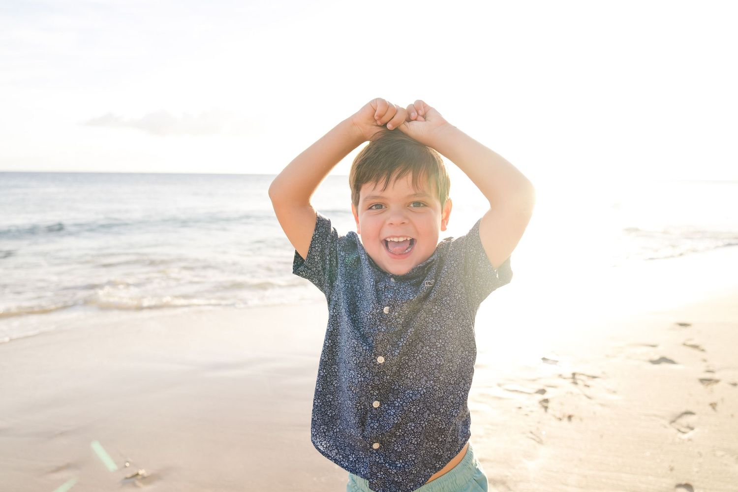 Five sequential images show a child making joyful expressions while playing on a sunny beach.
Oahu family photographer, Hawaii family photo