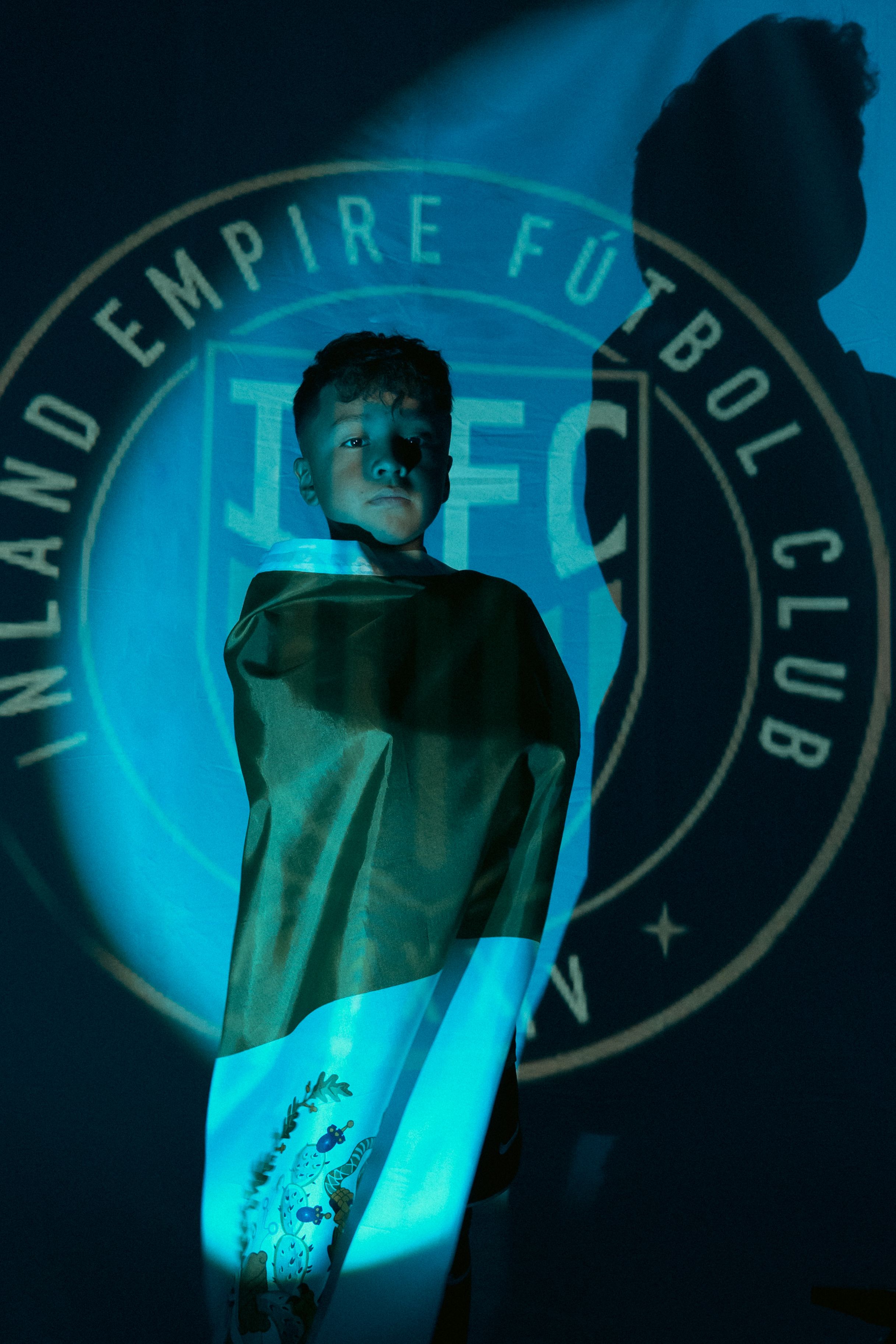 Dramatic blue-lit sports apparel photo featuring team logo projection.