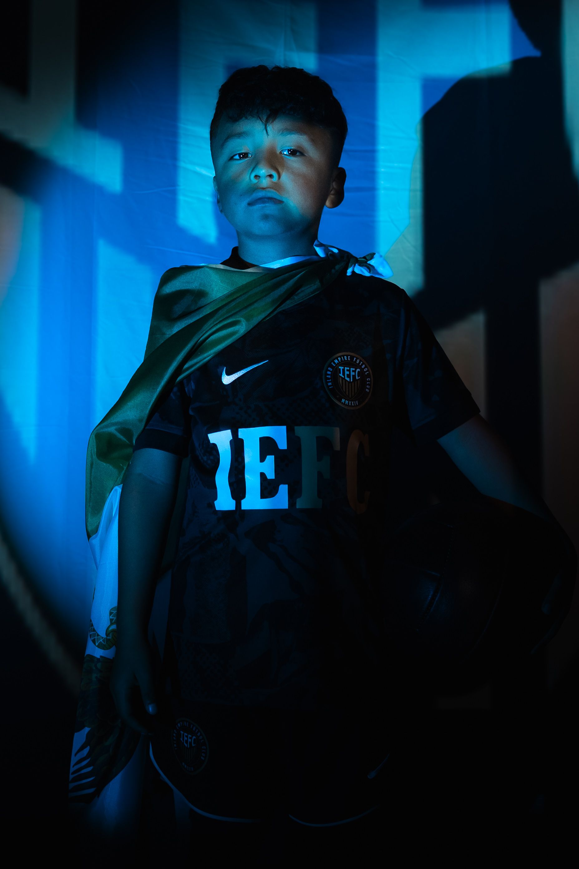 Moody sports fashion photo with blue lighting and dramatic shadows.