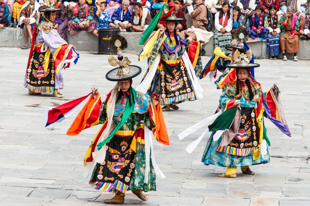 Native American performers in vibrant traditional regalia dance during a ceremonial powwow celebration.