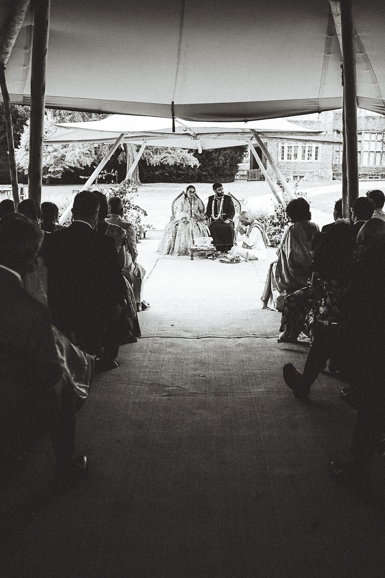 A couple shares a tender dance moment on a gravel patio at an outdoor evening event.