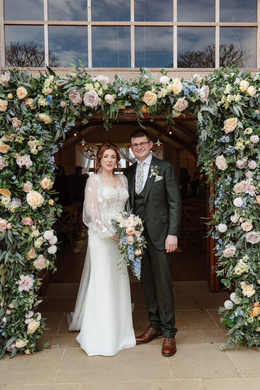 Hyde House Wedding Photographer Cotswolds Zara Davis Photography Gloucestershire Cheltenham bride groom exit under spring flowers barn