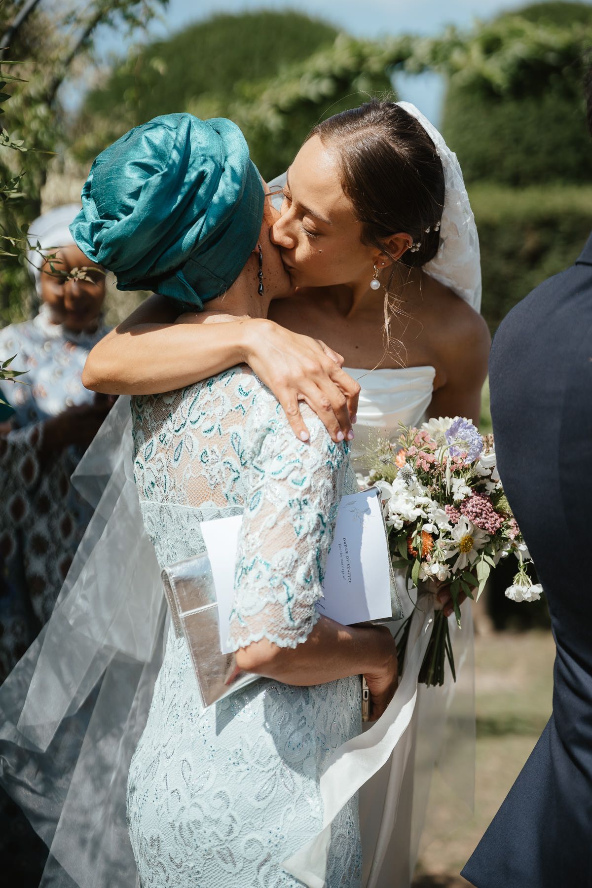 Romantic sequence of wedding photos showing newlyweds sharing kisses while holding a beautiful floral bouquet outdoors.