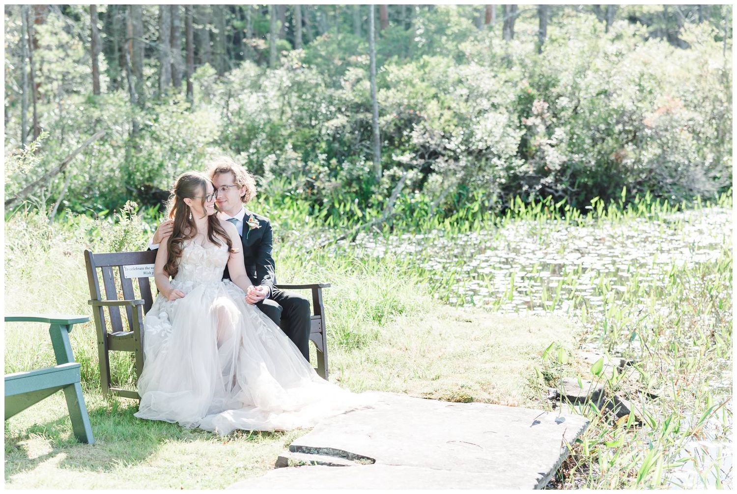 A bride twirls in a white wedding dress on a rustic wooden footbridge surrounded by lush greenery.