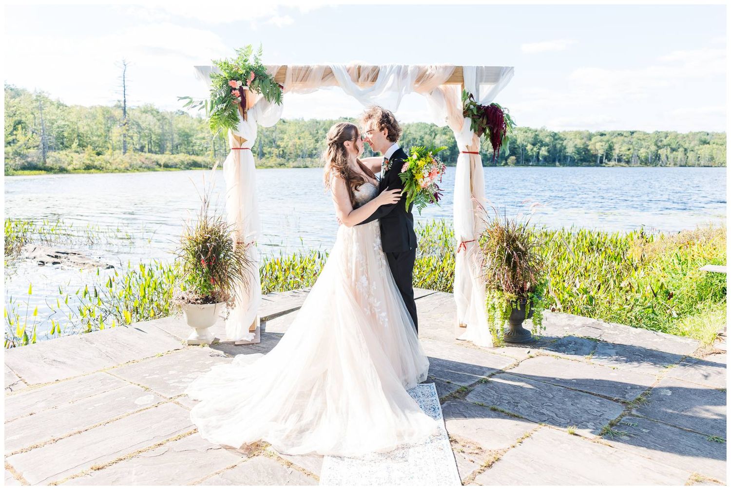 Wedding photos captured against a beautiful lake backdrop with summer greenery.
