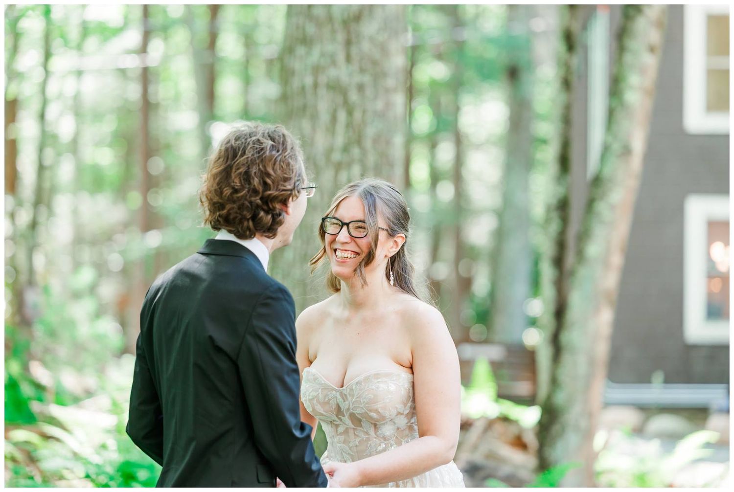 A couple shares a romantic moment together during their wedding ceremony in a lush green forest setting.