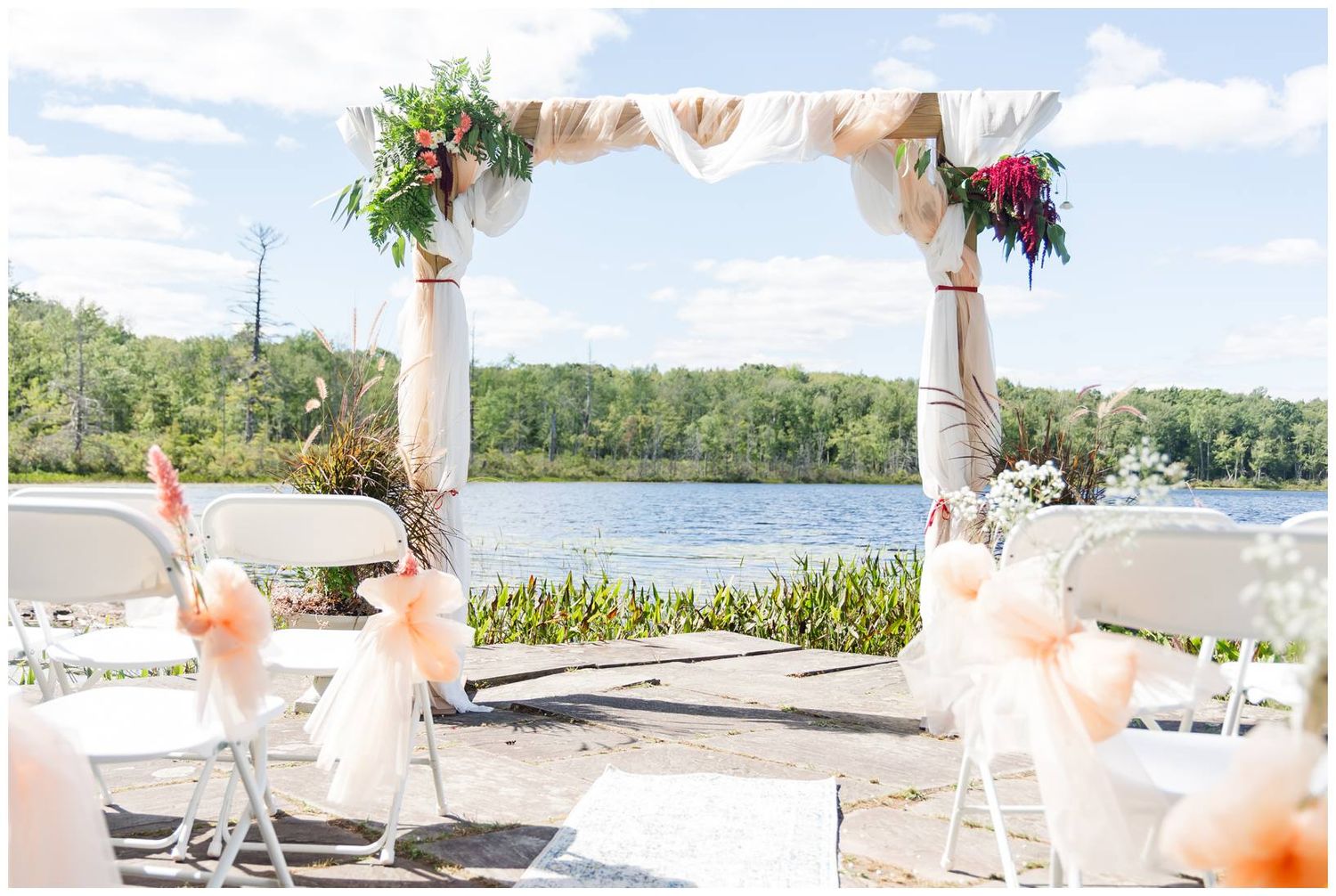 Romantic outdoor beach wedding reception setup with white tablecloths and decor in a tropical setting.