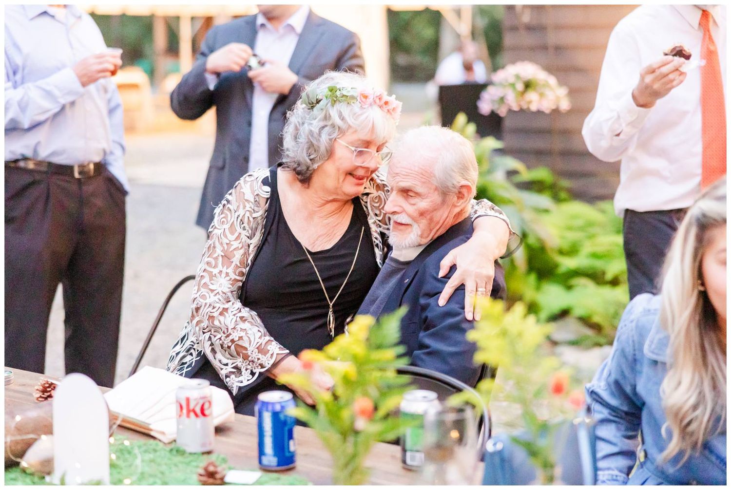 Wedding guests enjoying drinks and conversation at an outdoor garden reception.