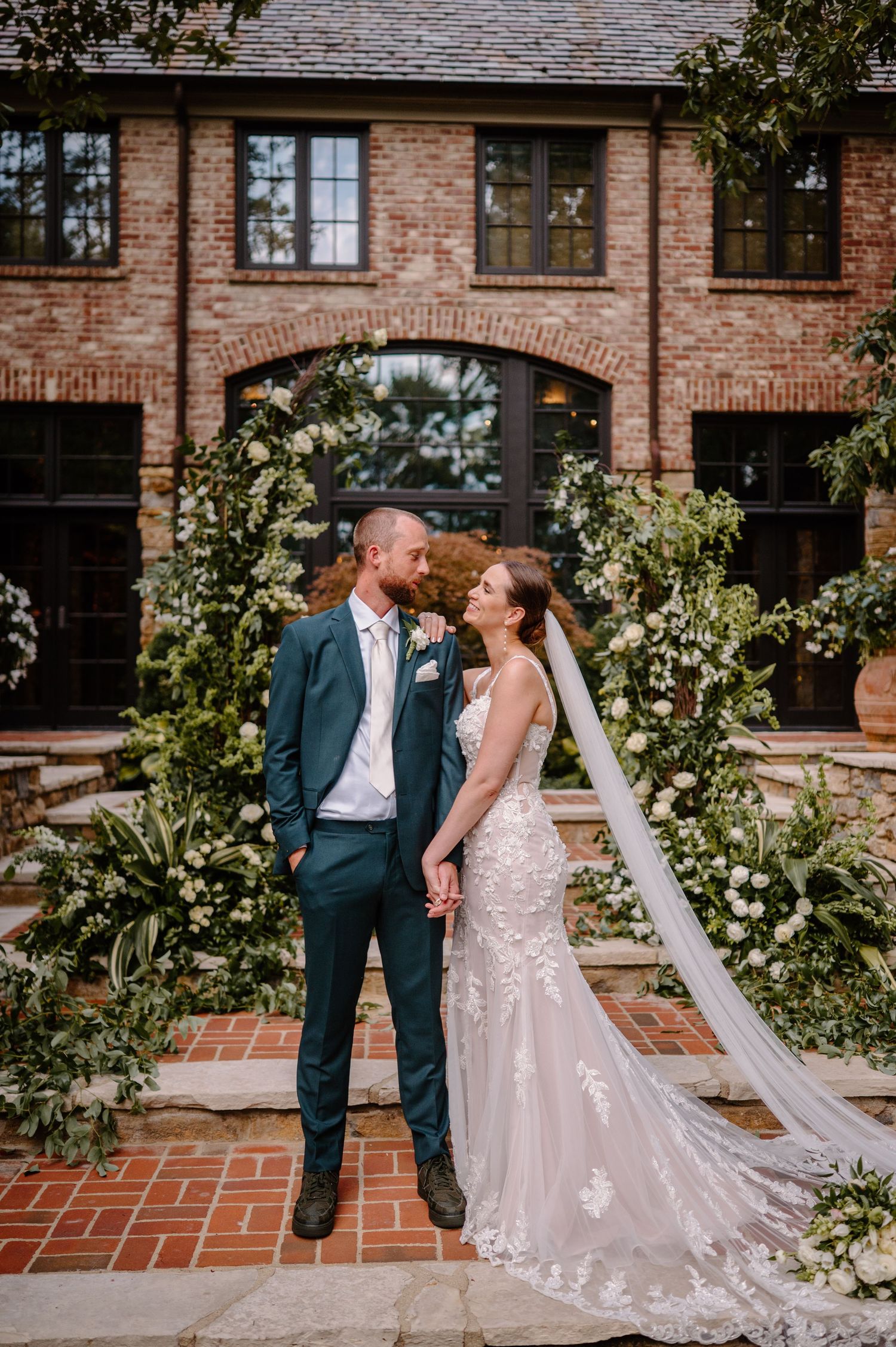A joyful moment between wedding party members as they share a dance outdoors on a sunny day.