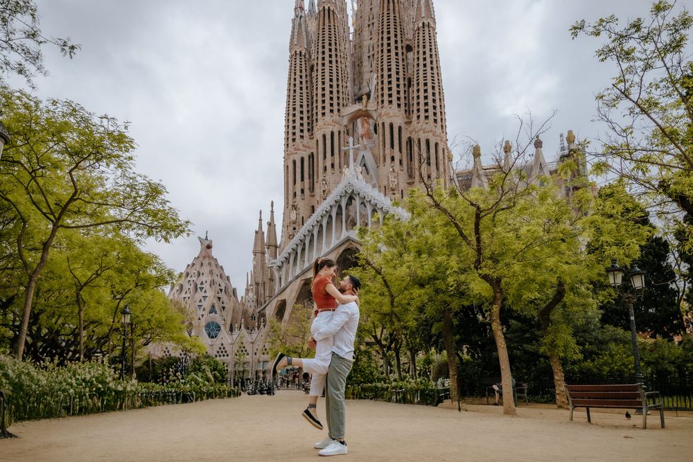 Tender kiss captured with Sagrada Familia behind them.