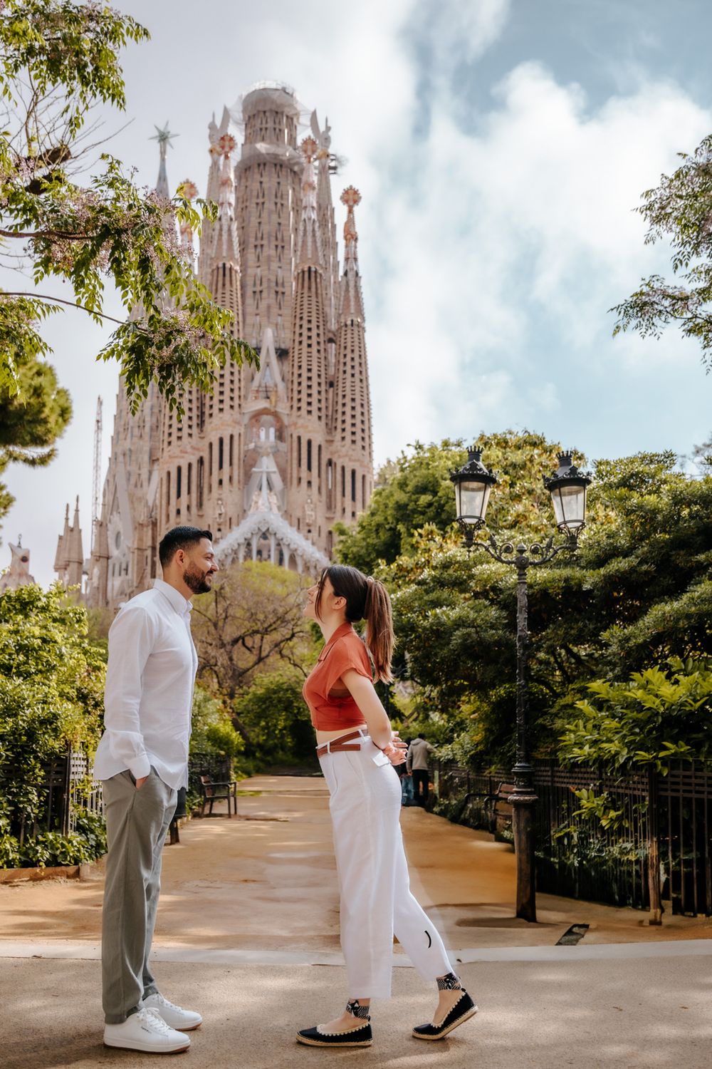 Couple holding hands in front of Barcelona’s iconic landmark.