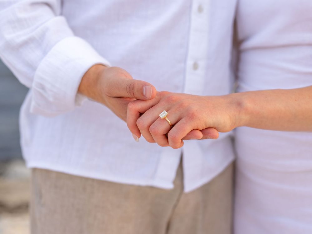 Close-up view of people holding hands together in a circle showing unity and support.