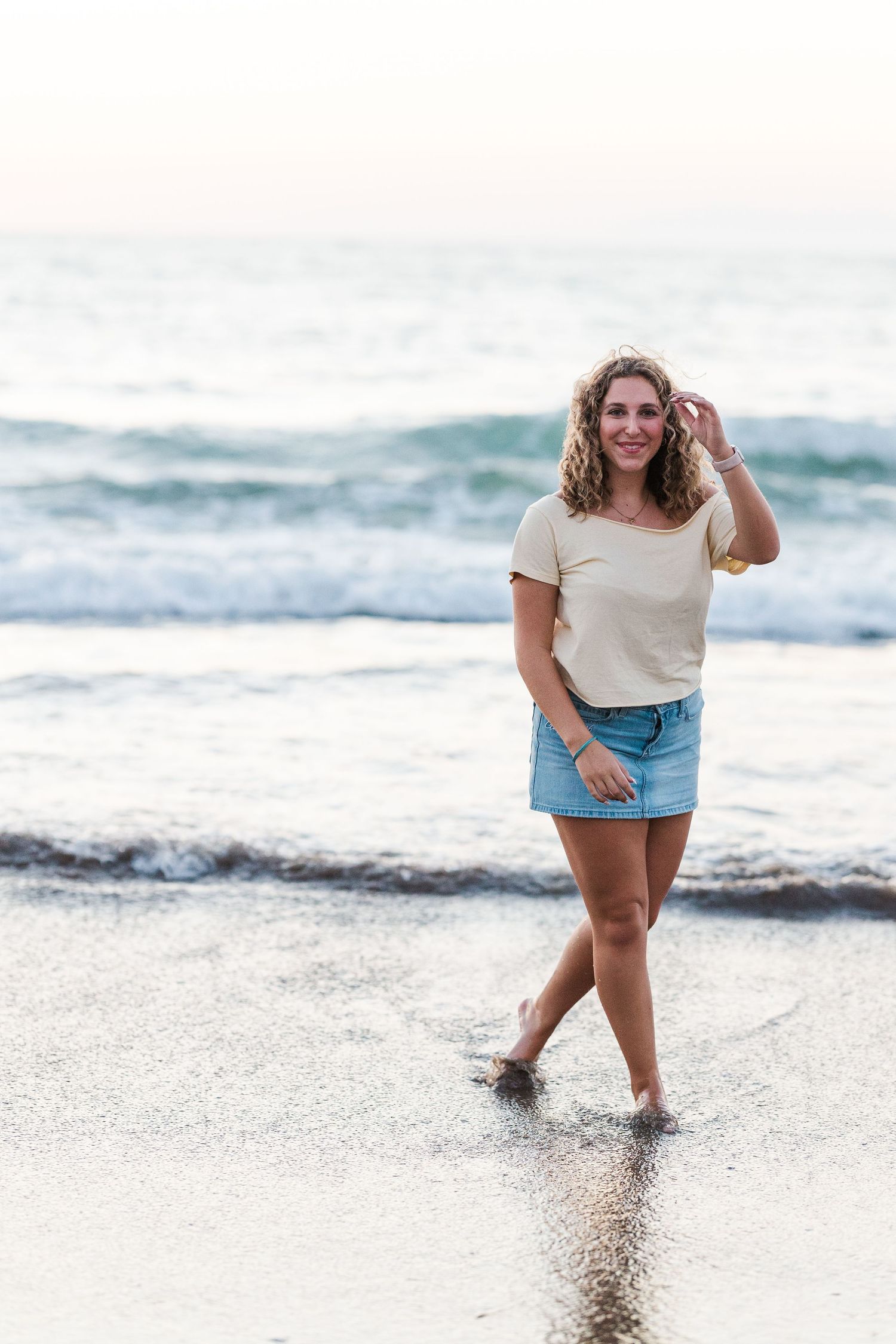 Casual beach portraits with waves and ocean in the background during golden hour.