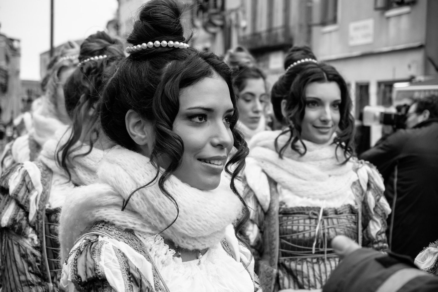 Black and white photo of people in traditional European folk costumes at a cultural festival celebration.