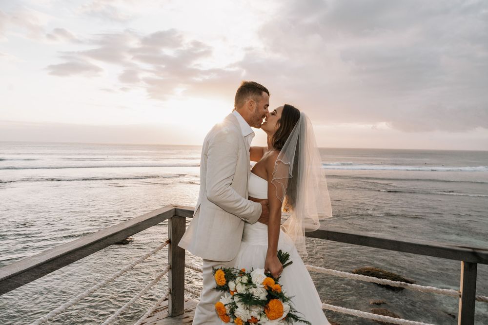A romantic beach wedding photo collection featuring couples embracing at sunset by the ocean.