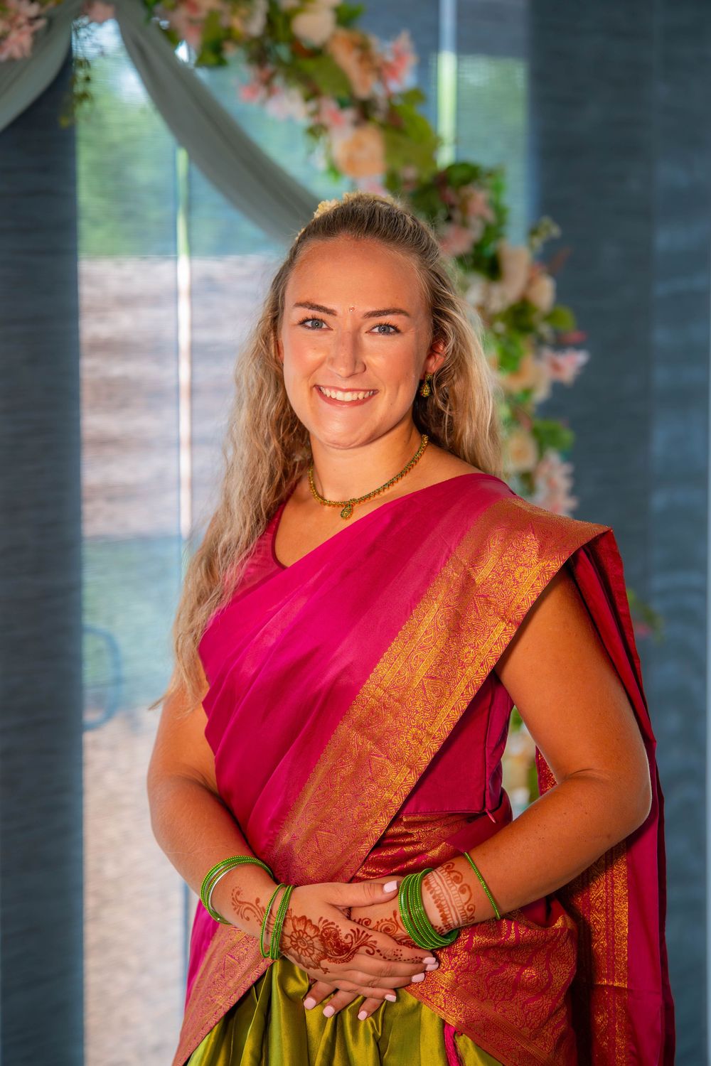 A person wearing red and gold traditional Indian attire poses elegantly. Nischitartham Quad Cities Hindi Indian Photographer