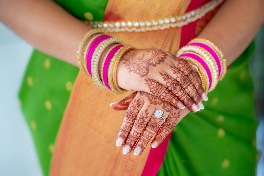 Close-up shots of hands decorated with intricate henna designs and gold jewelry. Nischitartham Quad Cities Hindi Indian Photographer
