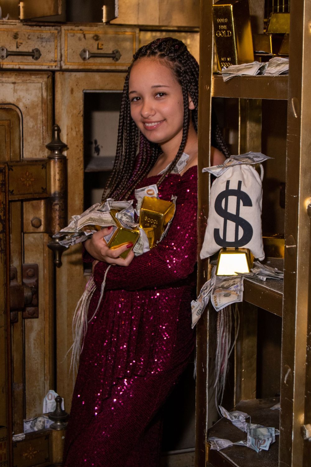 Person in sparkly burgundy dress poses with money in what appears to be a rustic wooden interior space.