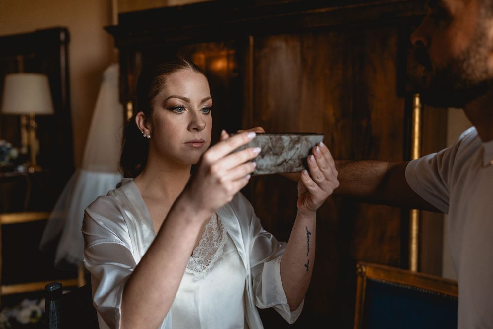 Wedding preparation scene in a rustic brick-walled room with warm lighting.