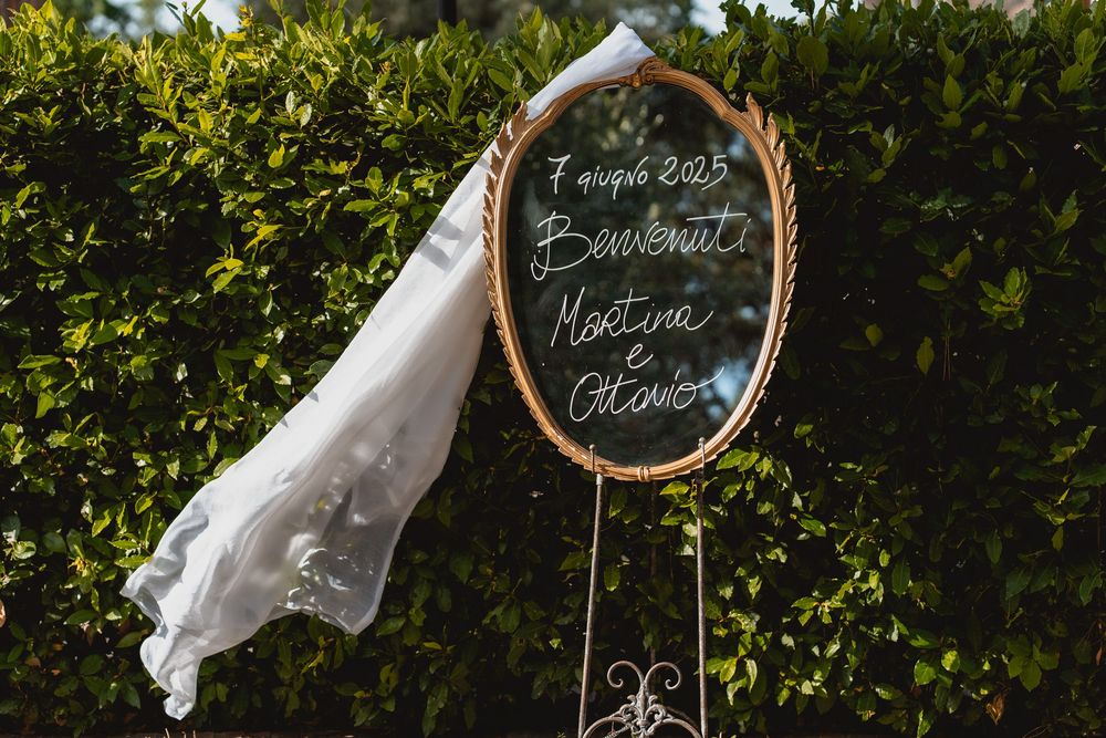Wedding decorations featuring chalkboard signs and greenery in an outdoor setting.