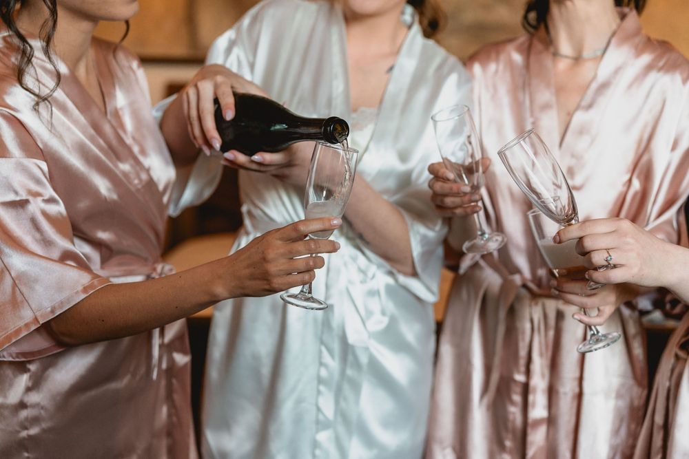 Wedding party wearing silk robes toasting with champagne glasses.