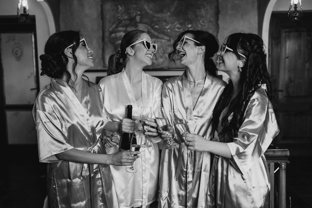 Group of people in white robes celebrating during wedding preparations.