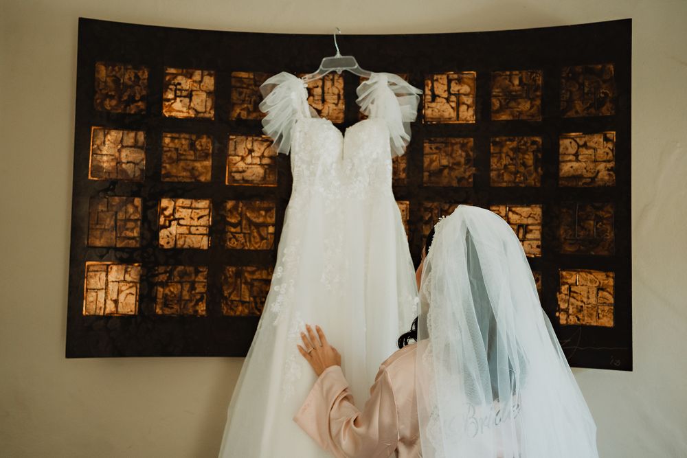 The bride admiring her dress hanging beautifully