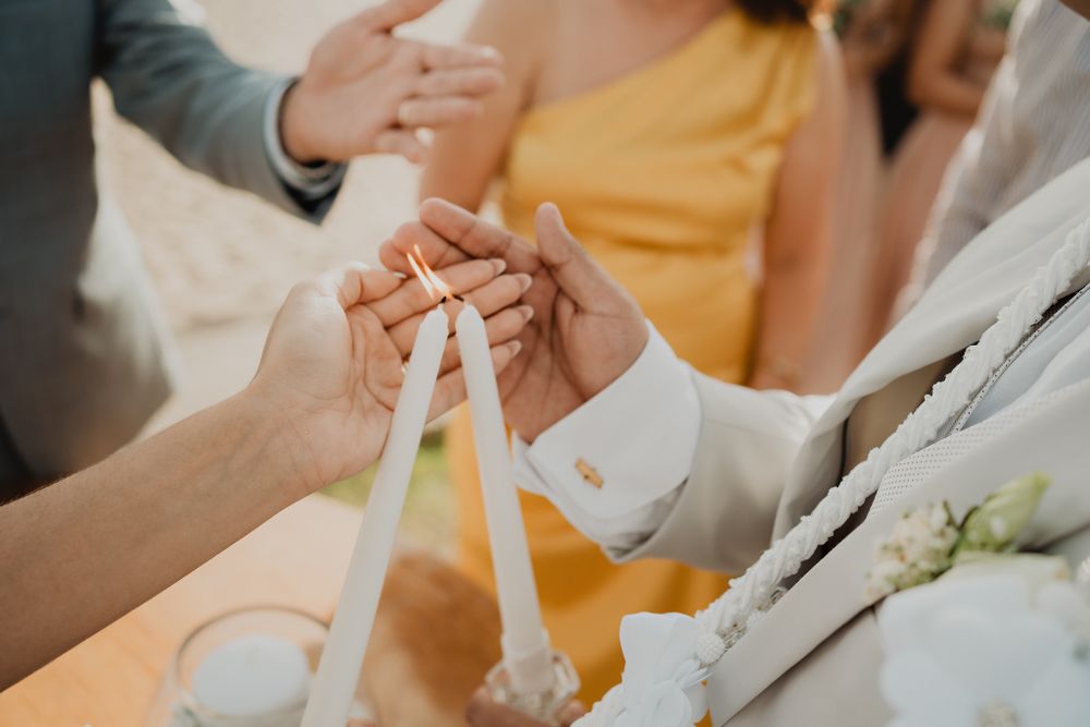 The couple holding candles, their flames symbolizing unity