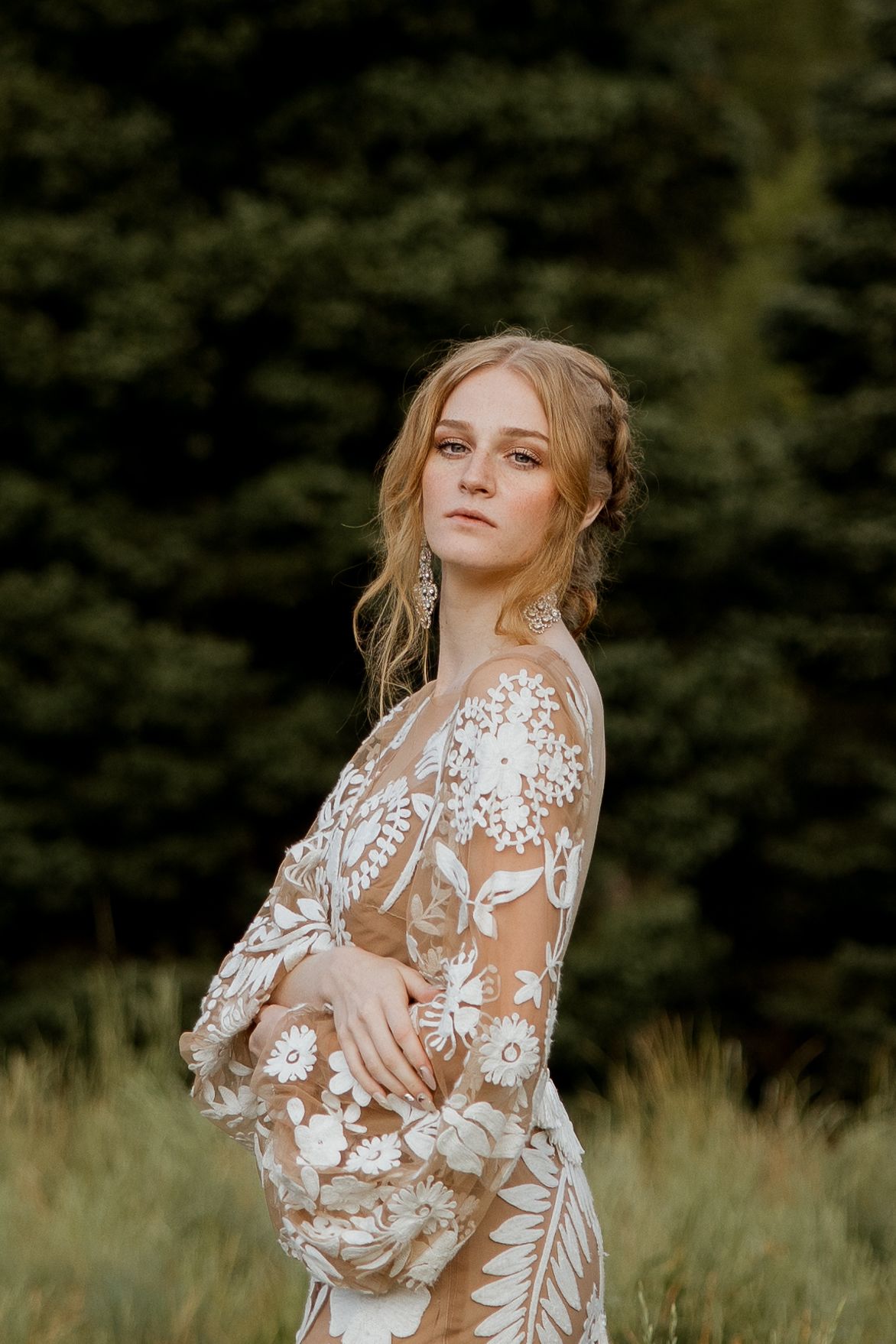 An ethereal bridal portrait featuring a sheer floral lace gown in a golden field.