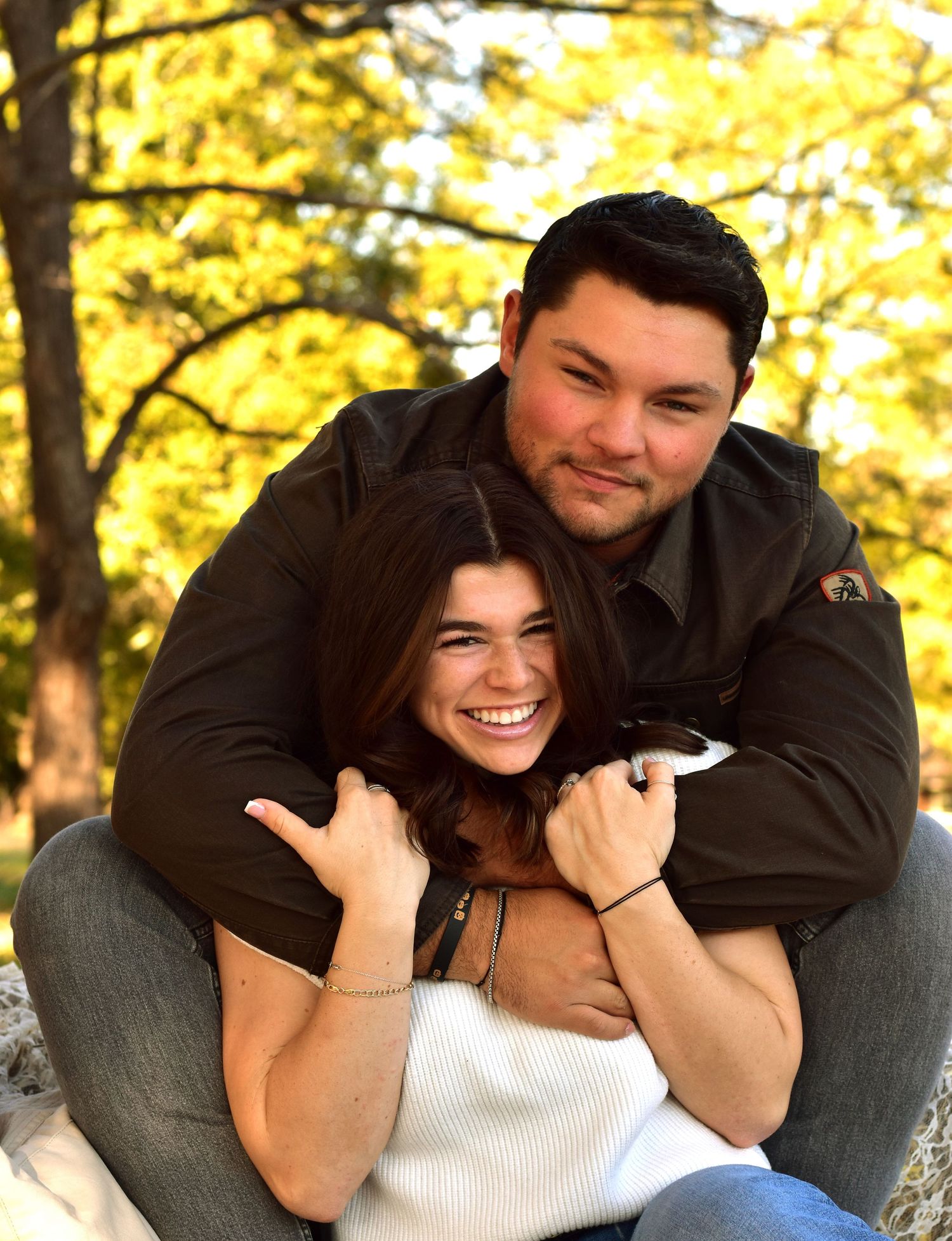 Candid embrace captured during autumn outdoor photography session.